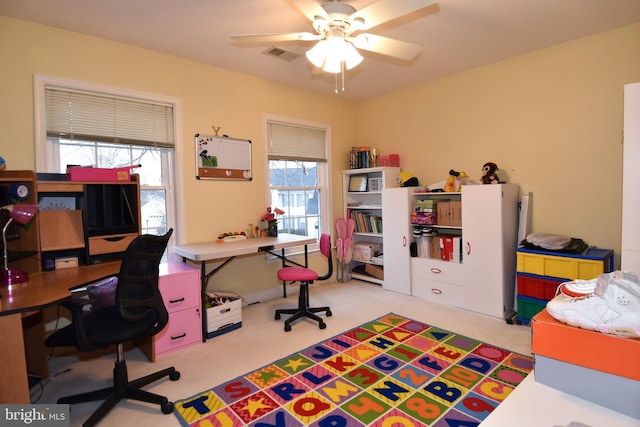 carpeted office space with ceiling fan