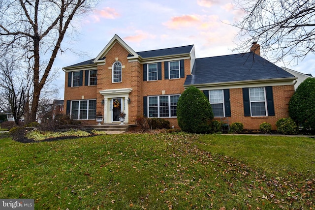 colonial-style house featuring a lawn