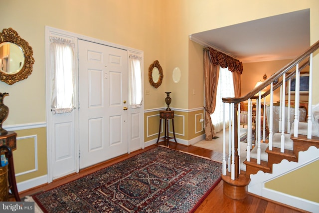 foyer entrance with wood-type flooring and ornamental molding