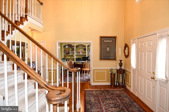 foyer entrance with dark hardwood / wood-style floors and a high ceiling