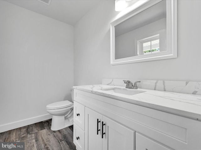 bathroom with hardwood / wood-style flooring, vanity, and toilet