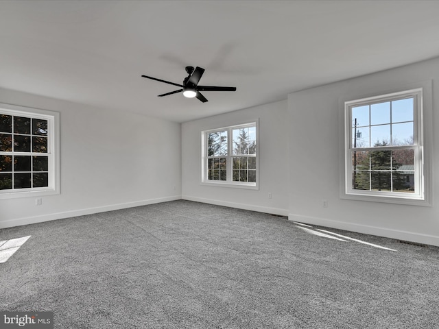 carpeted spare room with ceiling fan and a wealth of natural light