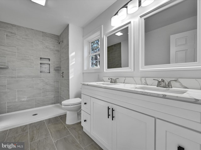 bathroom featuring vanity, toilet, and tiled shower