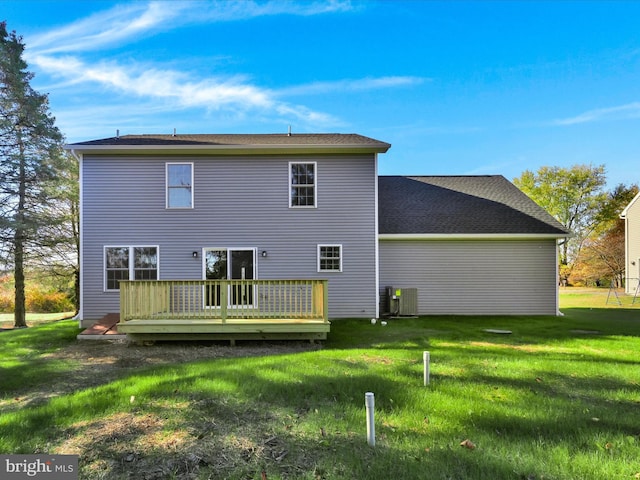 rear view of property featuring a deck, central AC unit, and a lawn