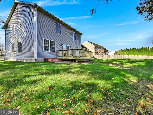 rear view of house with a lawn and a deck