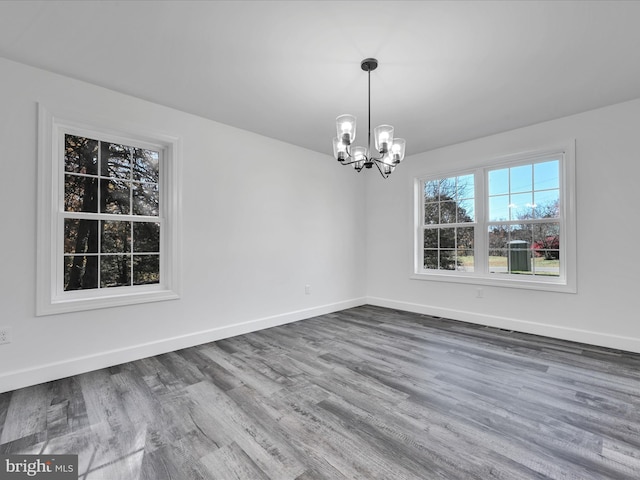 unfurnished dining area with a chandelier and hardwood / wood-style flooring