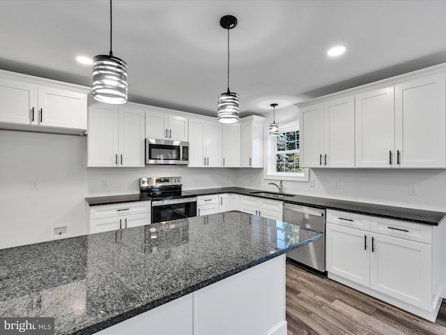 kitchen with appliances with stainless steel finishes, white cabinetry, pendant lighting, and sink