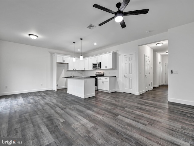 kitchen featuring dark hardwood / wood-style flooring, stainless steel appliances, a center island, white cabinetry, and hanging light fixtures