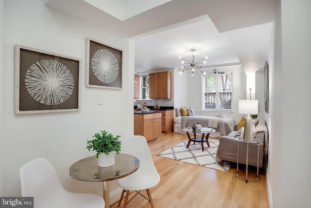 living room featuring light wood-type flooring and an inviting chandelier