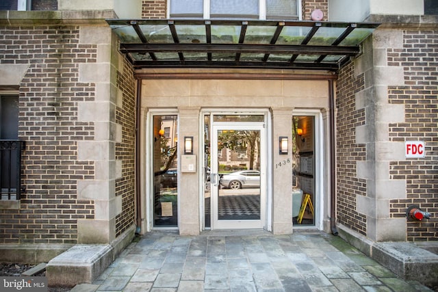 view of exterior entry featuring brick siding