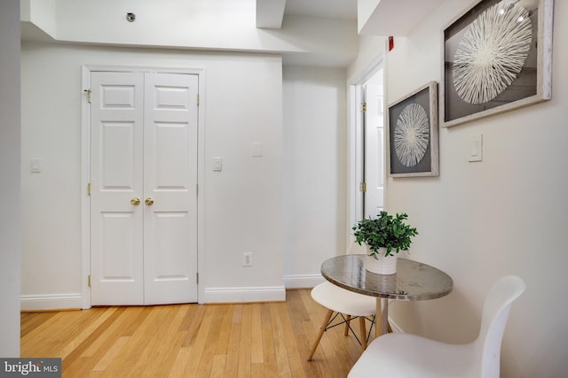 sitting room with baseboards and light wood finished floors