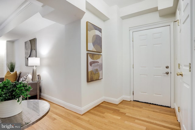 foyer entrance with baseboards and wood finished floors