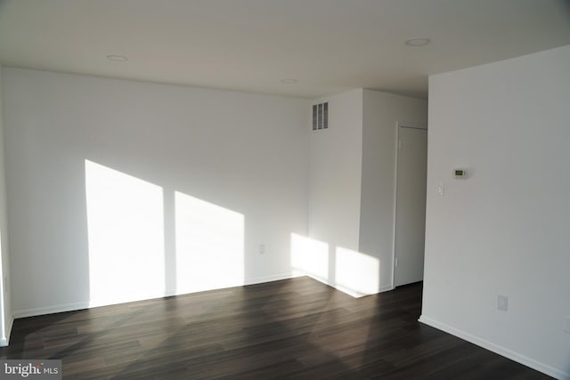 unfurnished room with dark hardwood / wood-style flooring