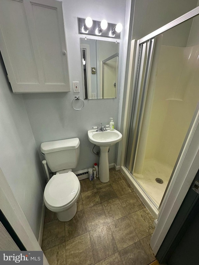 bathroom featuring a shower with door and toilet