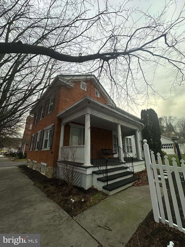 property exterior at dusk featuring covered porch