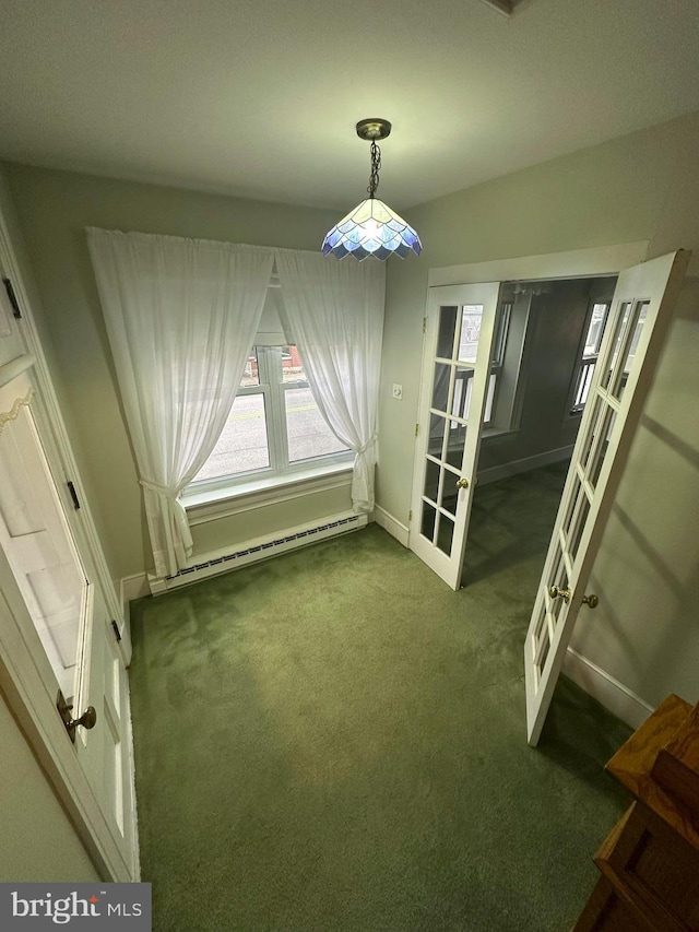 unfurnished dining area featuring dark colored carpet and a baseboard radiator