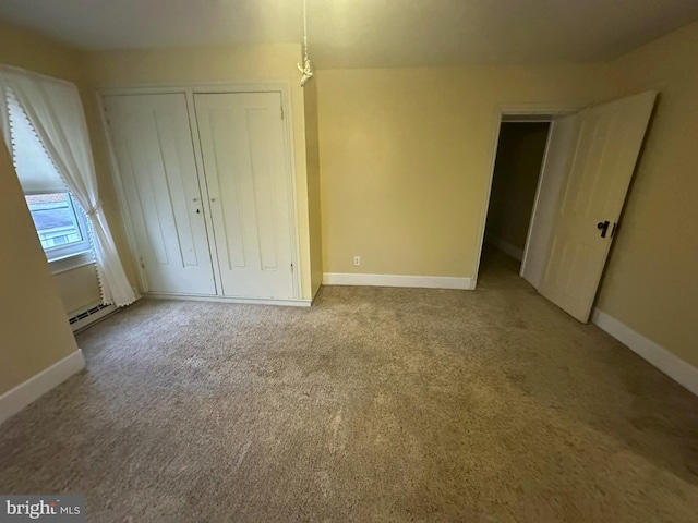 unfurnished bedroom with a closet, carpet, and a baseboard radiator