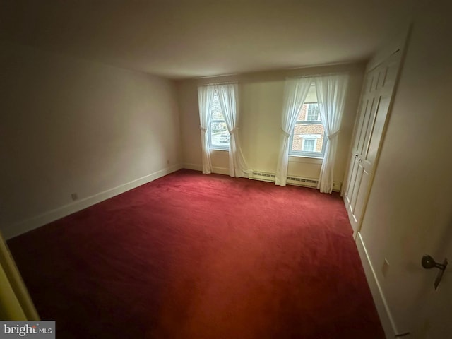 spare room with carpet flooring and a baseboard radiator