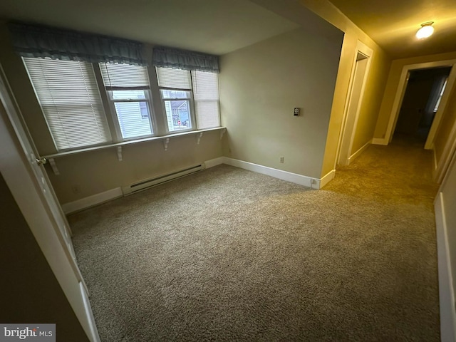 spare room featuring baseboard heating and light colored carpet