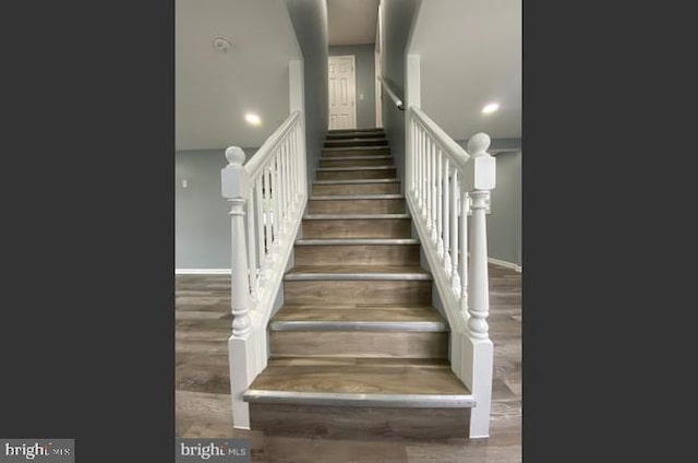 staircase with hardwood / wood-style flooring