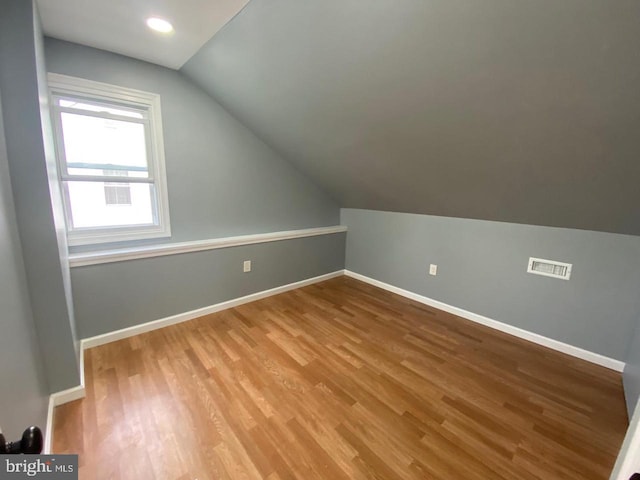 bonus room with hardwood / wood-style flooring and vaulted ceiling