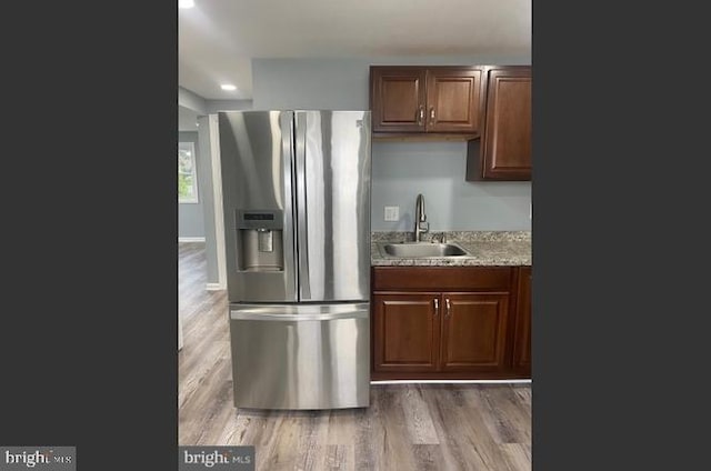 kitchen with dark hardwood / wood-style flooring, stainless steel fridge with ice dispenser, and sink