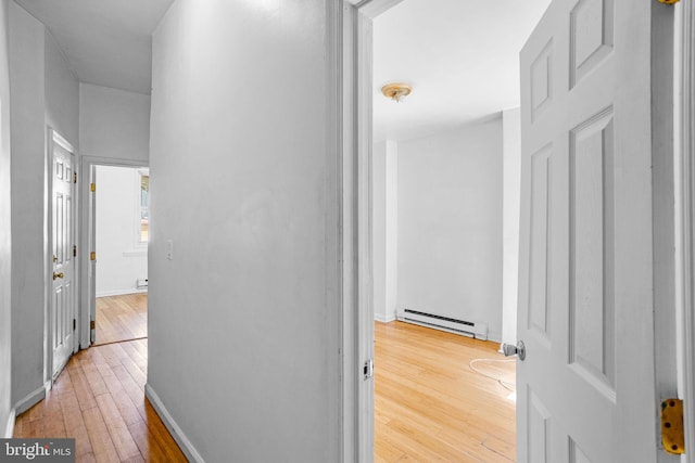 corridor featuring light wood-type flooring and baseboard heating