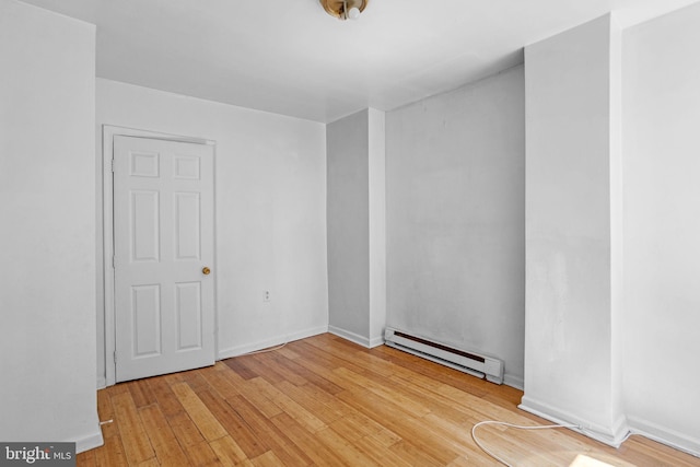 spare room with light wood-type flooring and baseboard heating