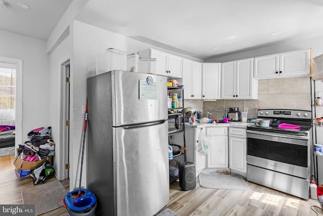 kitchen with white cabinets, stainless steel appliances, and light wood-type flooring