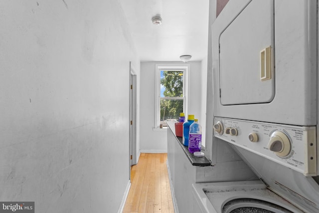 washroom with light wood-type flooring and stacked washer / drying machine