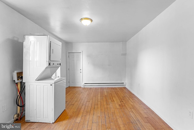 clothes washing area with light hardwood / wood-style floors, baseboard heating, and stacked washer / dryer