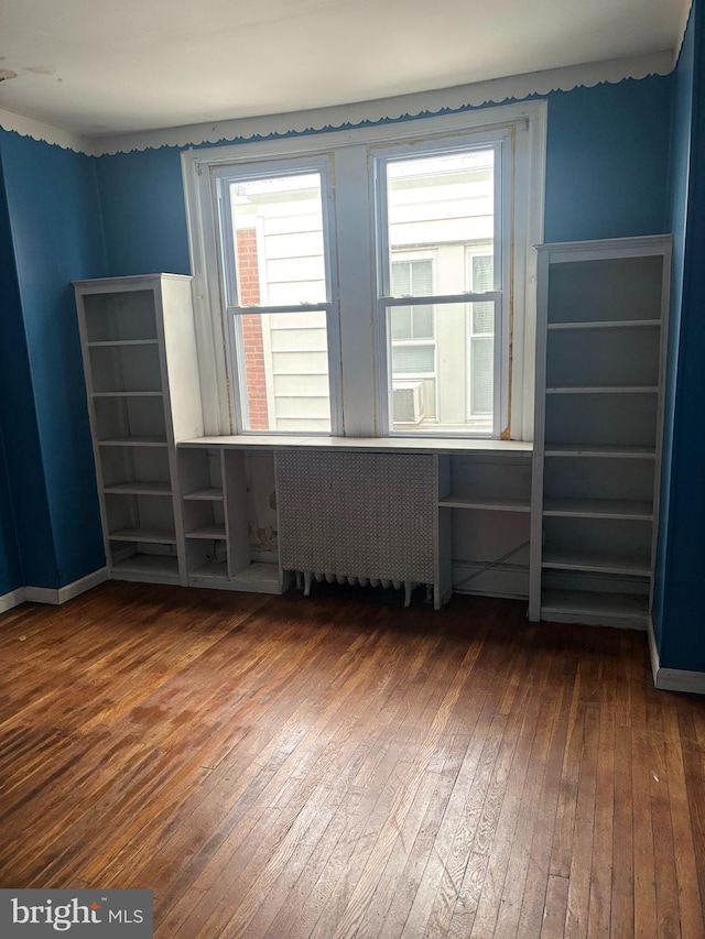 empty room with hardwood / wood-style flooring and radiator