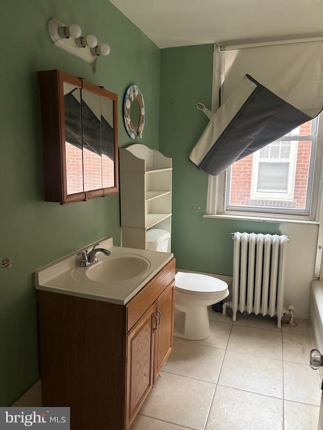 bathroom with toilet, vanity, tile patterned floors, and radiator