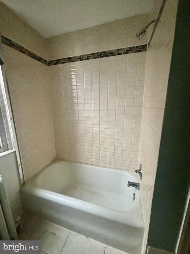 bathroom featuring radiator heating unit and tiled shower / bath