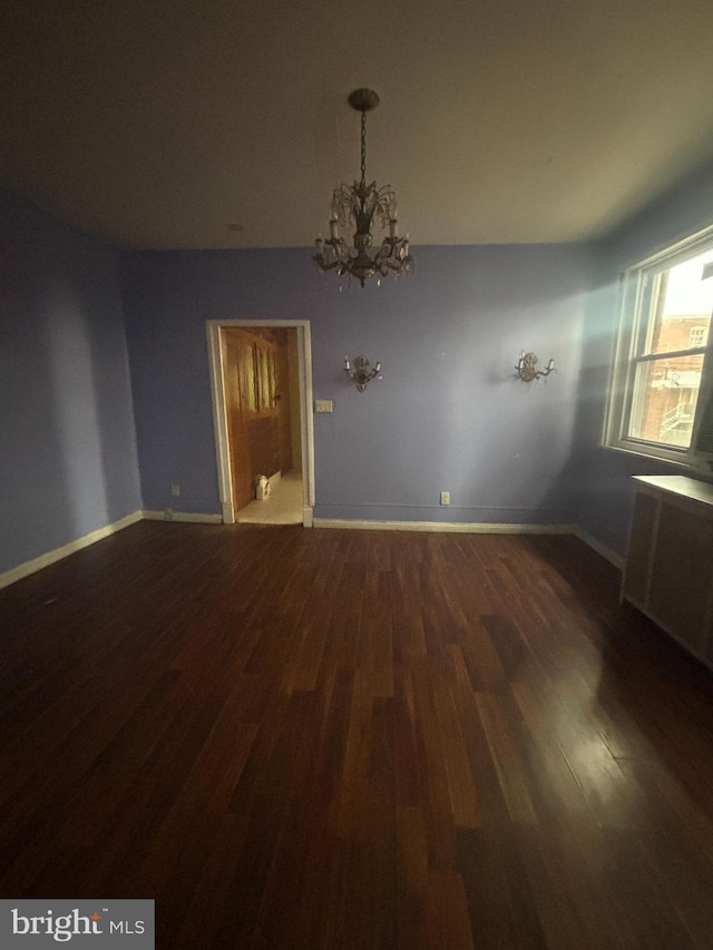 interior space featuring radiator heating unit, dark hardwood / wood-style floors, and an inviting chandelier