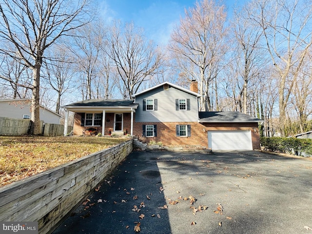 tri-level home with a porch and a garage