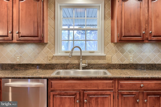 kitchen with backsplash, dishwasher, sink, and dark stone counters