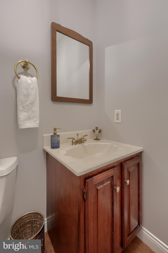 bathroom featuring vanity, hardwood / wood-style flooring, and toilet