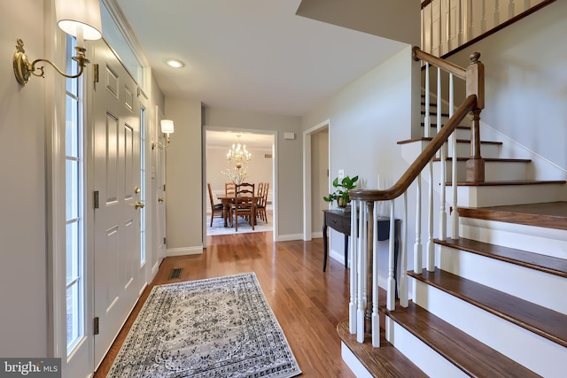 entrance foyer with a notable chandelier and hardwood / wood-style flooring