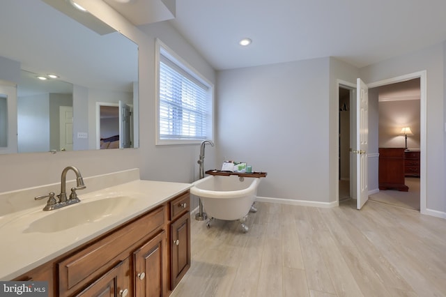 bathroom featuring hardwood / wood-style floors, vanity, and a bath