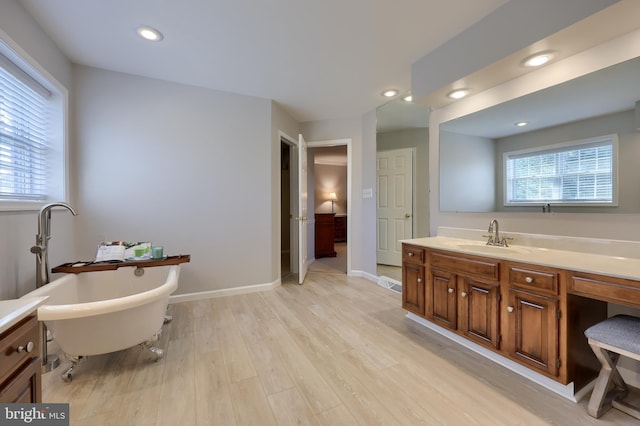 bathroom featuring a tub to relax in, vanity, and hardwood / wood-style flooring