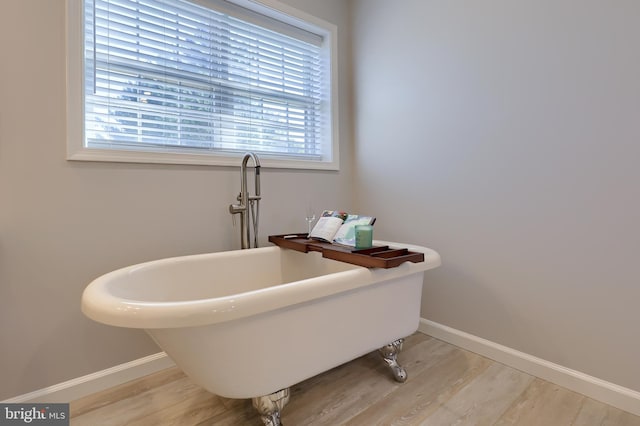 bathroom with hardwood / wood-style floors and a bathing tub