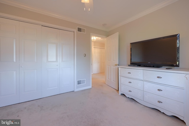 unfurnished bedroom with ceiling fan, light colored carpet, ornamental molding, and a closet