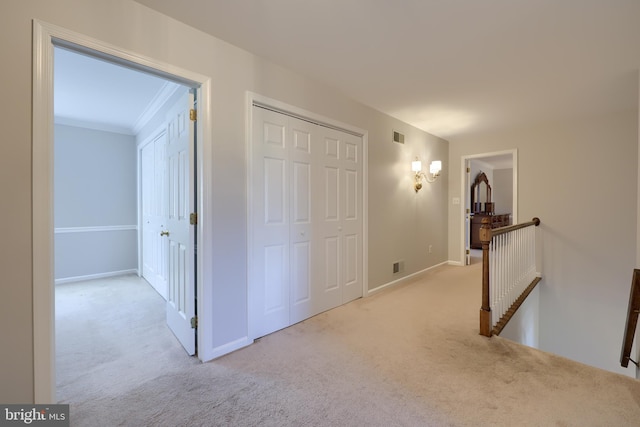 hall featuring light colored carpet and crown molding