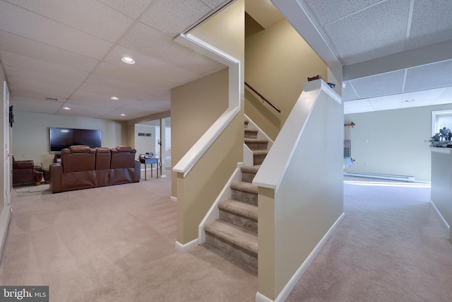 stairway with carpet, a paneled ceiling, and a baseboard radiator