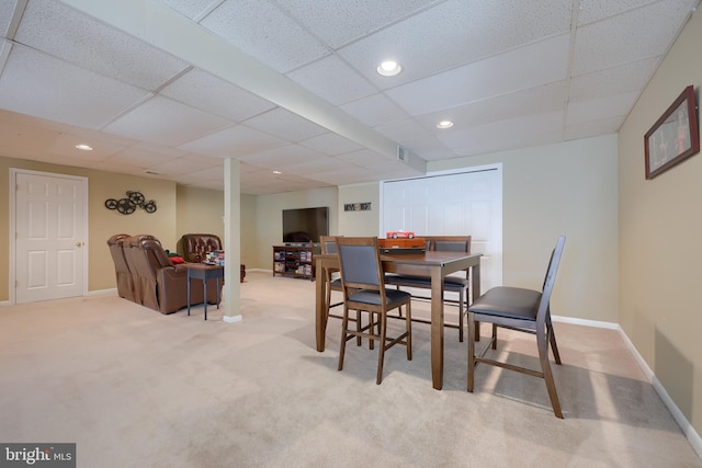 carpeted dining room with a paneled ceiling