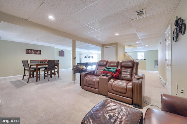 home theater featuring a paneled ceiling, light colored carpet, and plenty of natural light