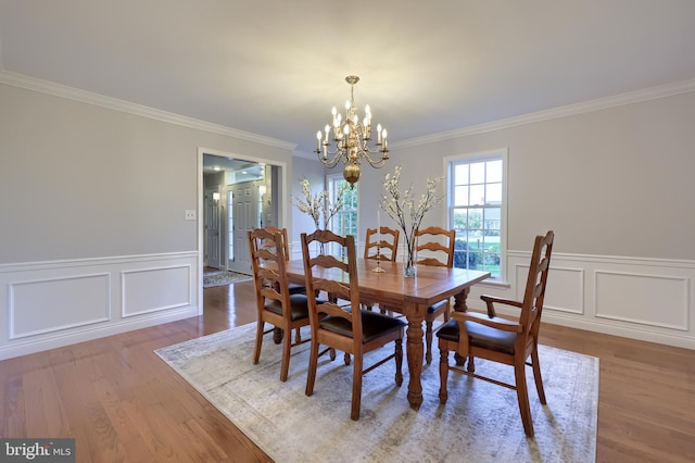 dining space featuring a chandelier, crown molding, and wood-type flooring