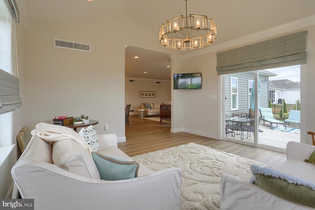 living room with light wood-type flooring and an inviting chandelier