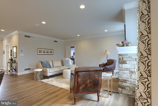 living room featuring hardwood / wood-style floors, a fireplace, and crown molding